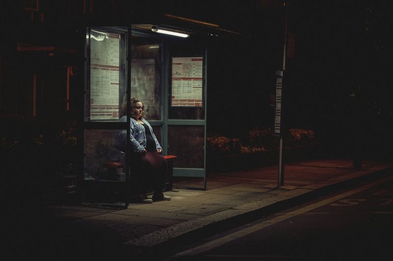 Jessica Gunning sits alone at a bus stop at night in Baby Reindeer